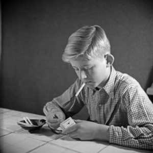 A curious boy trying his first cigarette, Germany 1940s. A curious boy trying his first cigarette, Germany 1940s.